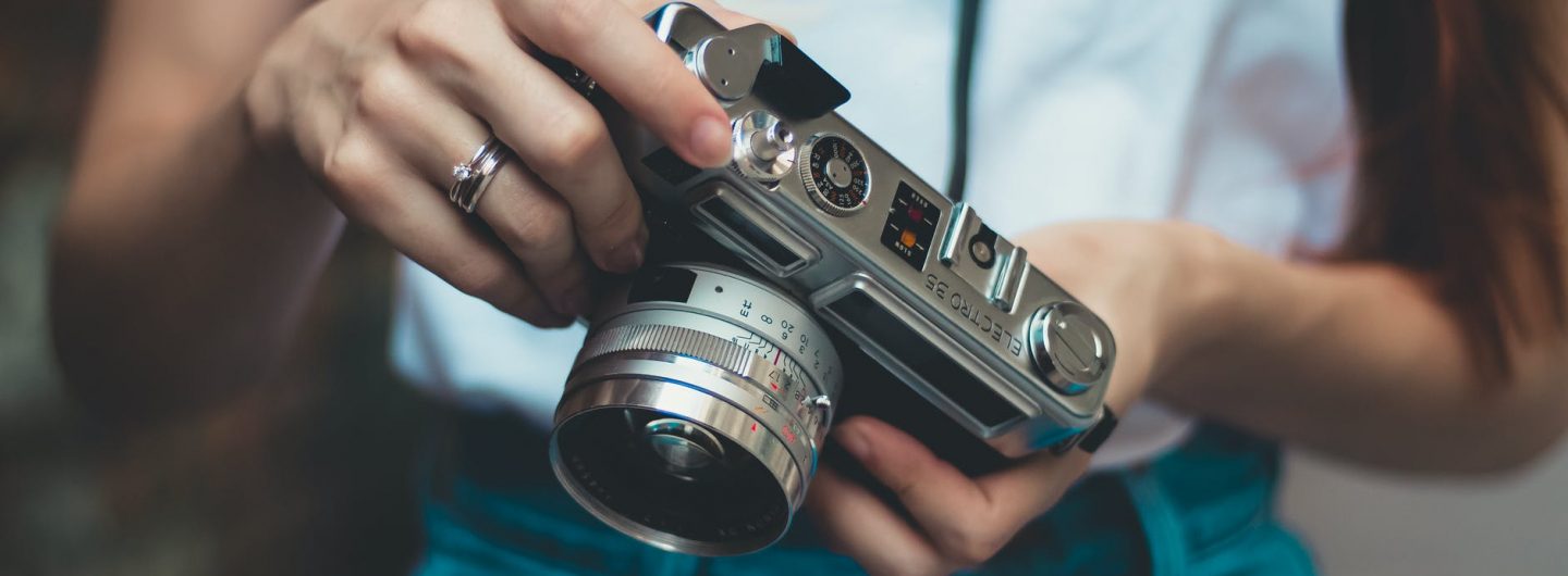 woman in white shirt holding analog camera